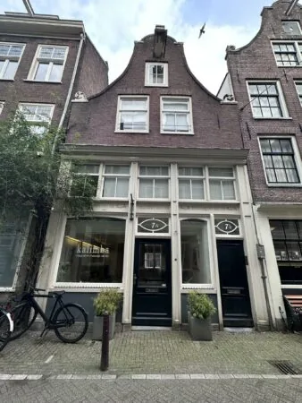 Voorgevel van een karakteristiek Amsterdams grachtenpand aan de Eerste Lindendwarsstraat met het massagebedrijf Kalimba op de begane grond.